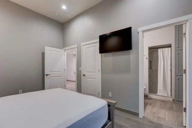 a bedroom with a bed and a flat screen tv