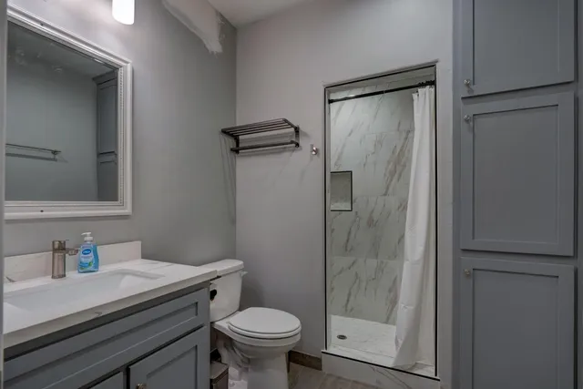 a bathroom with a granite countertop sink toilet and shower
