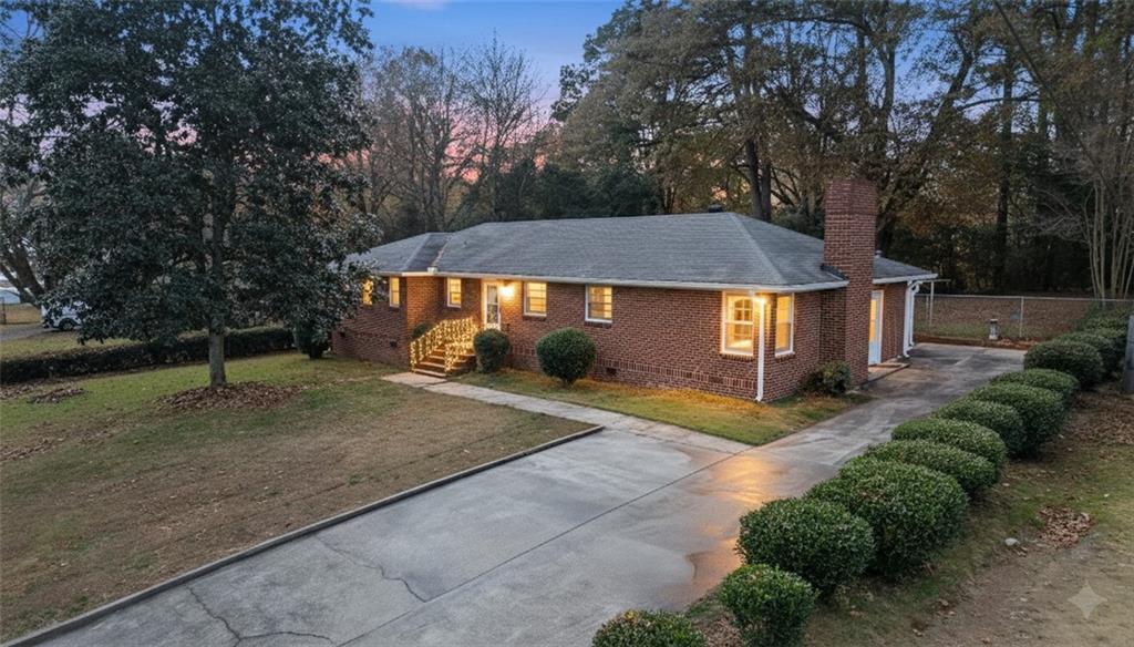 a view of a white house with a large tree and a yard