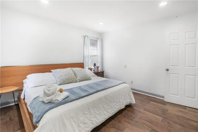 a bedroom with a bed and a wooden floor