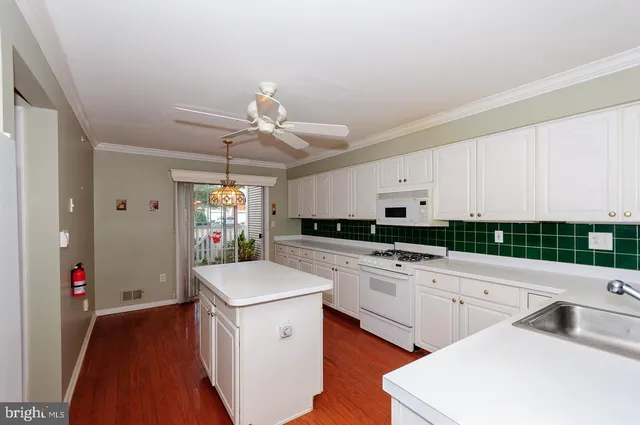 a kitchen with white cabinets and white appliances