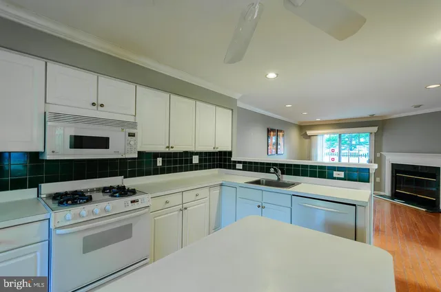 a kitchen with granite countertop a sink stainless steel appliances and cabinets