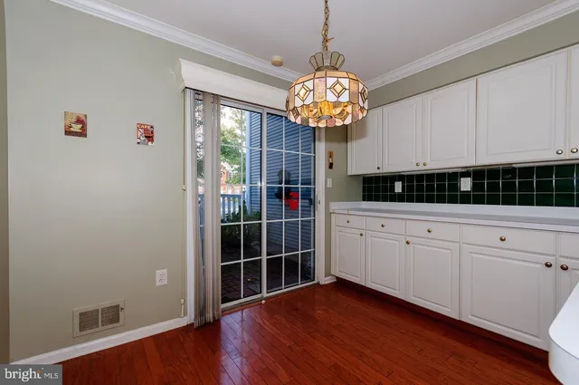 a view of a room with wooden floor and chandelier