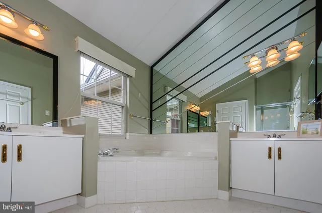 a bathroom with a bathtub sink and mirror