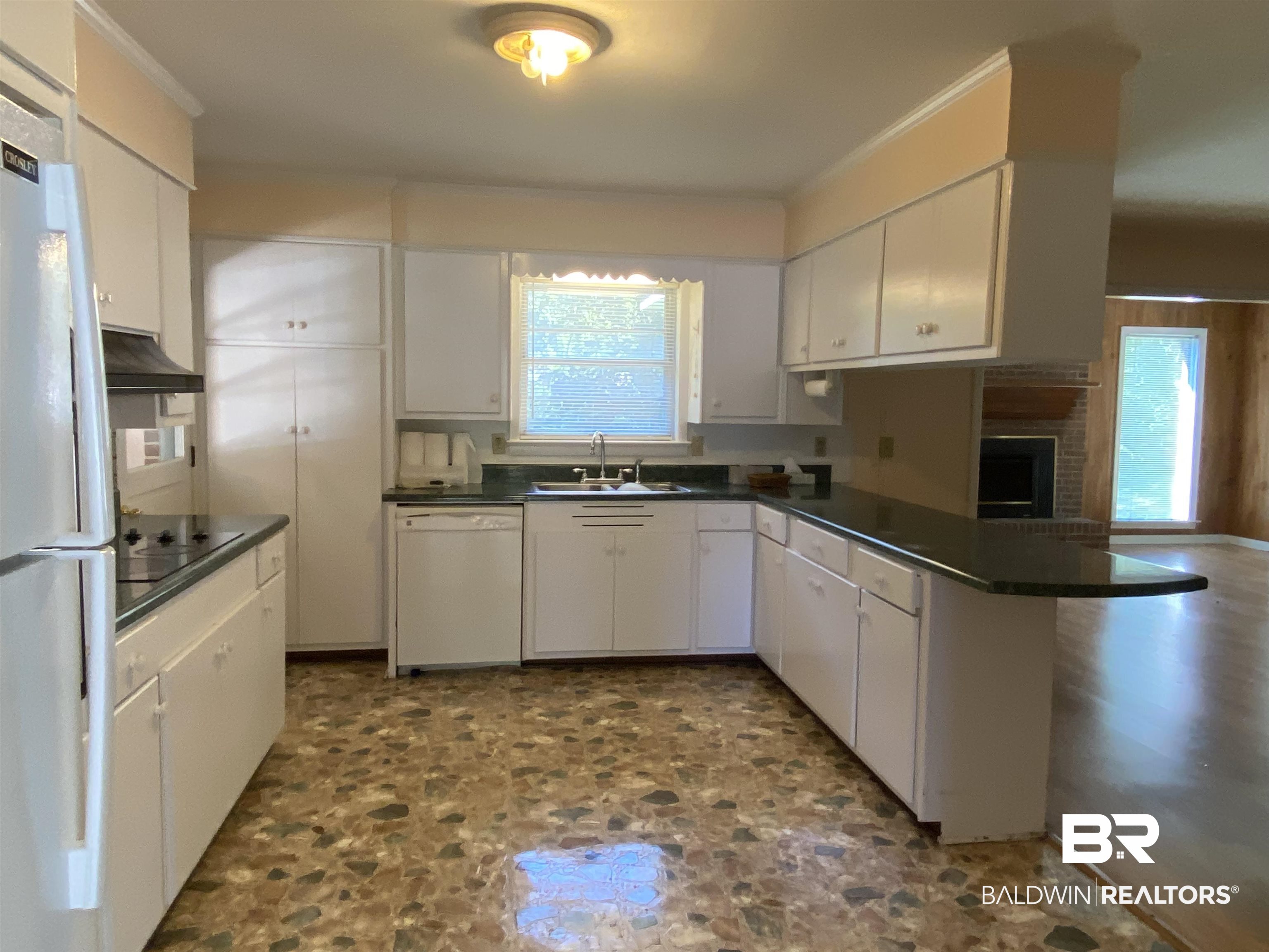 106 Terry Drive Brewton, AL 36426 - Photo 6 of 25 Kitchen with dark countertops, white cabinetry, a peninsula, and white appliances