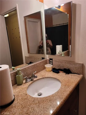 a bathroom with a granite countertop sink and a mirror