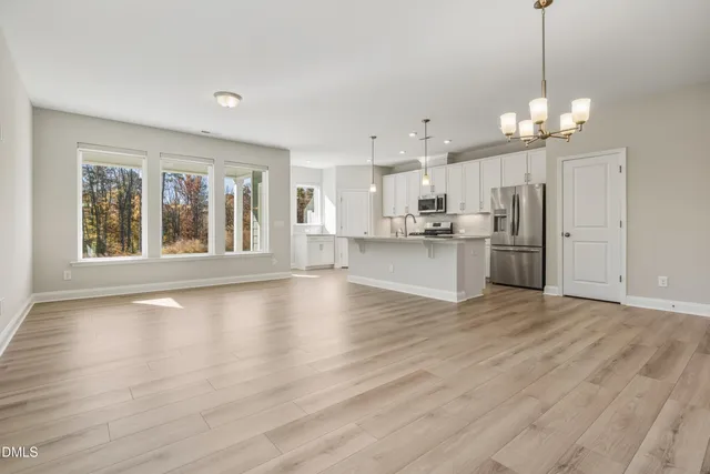 a view of a kitchen with a stove wooden cabinet a kitchen island and windows