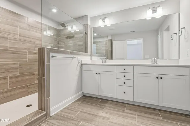 a bathroom with a shower sink and mirror