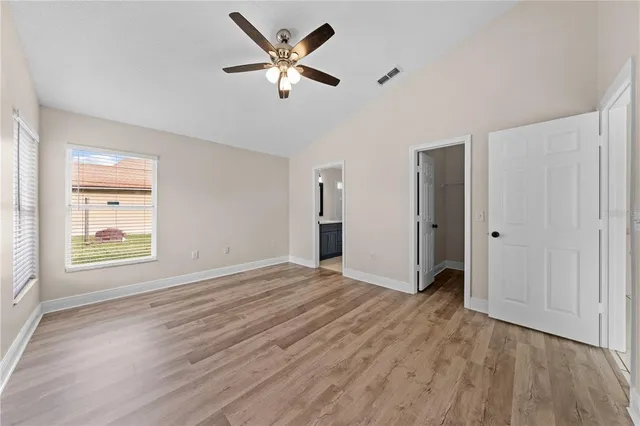 an empty room with window and a ceiling fan