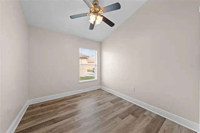 an empty room with a window and a fan