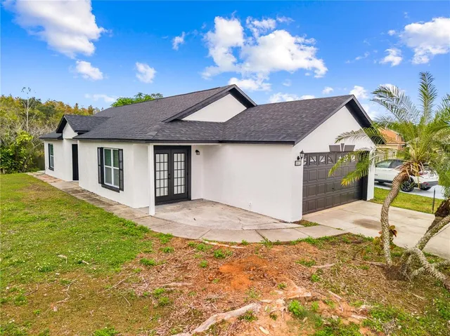 a view of a house with backyard and a tree