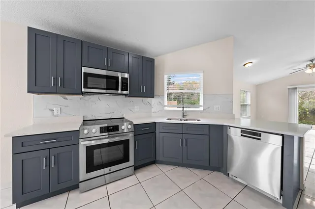 a kitchen with stainless steel appliances granite countertop a stove microwave and sink
