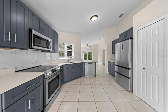 a kitchen with stainless steel appliances granite countertop a refrigerator stove and sink