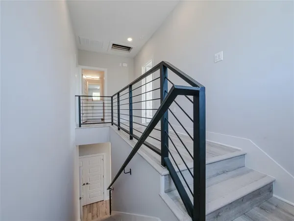 a view of a hallway with wooden floor and entryway