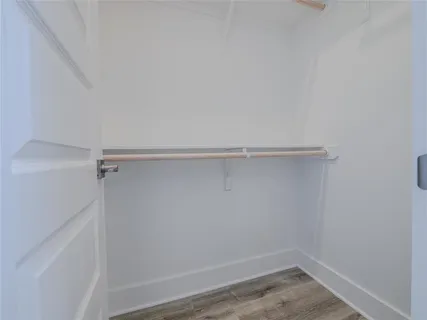 a bathroom with a toilet a sink and wooden floor