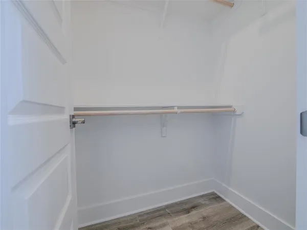 a bathroom with a toilet a sink and wooden floor