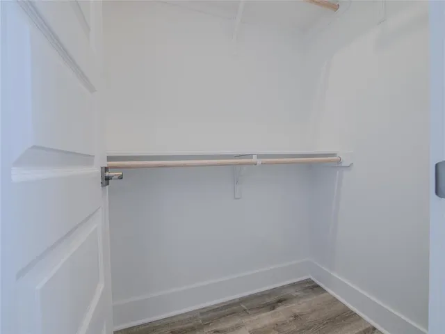 a bathroom with a toilet a sink and wooden floor