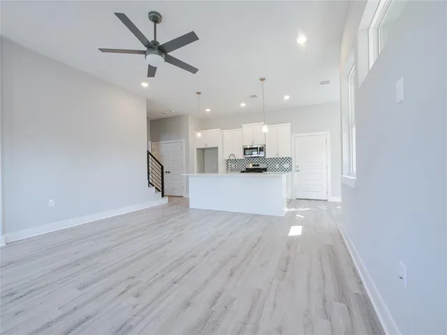 a view of an empty room with kitchen appliances and a window