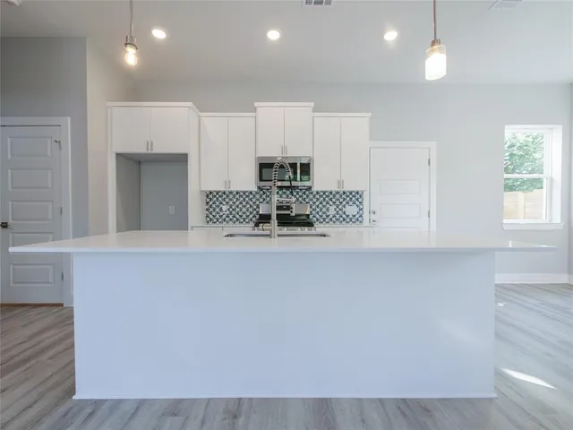 a view of a kitchen with a sink and wooden floor