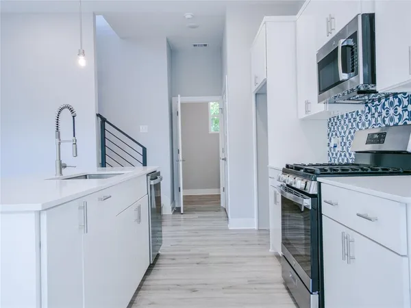 a kitchen with kitchen island white cabinets and stainless steel appliances