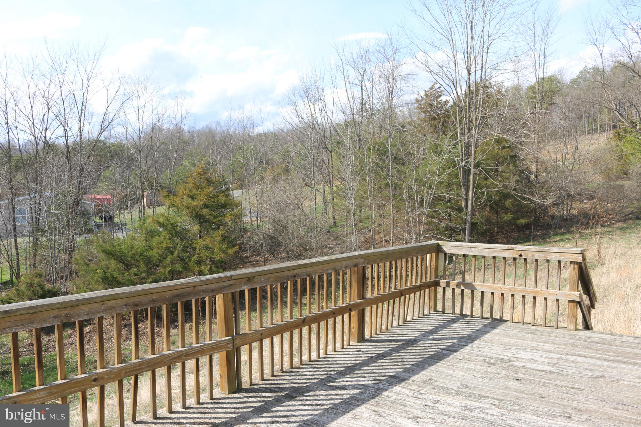 156 Squirrel Den Road Maysville, WV 26833 - Photo 5 of 41 a view of a wooden deck and trees with wooden fence
