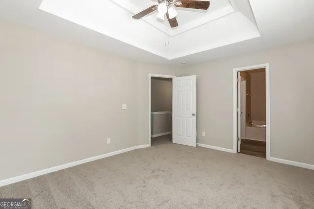an empty room with a ceiling fan and a window