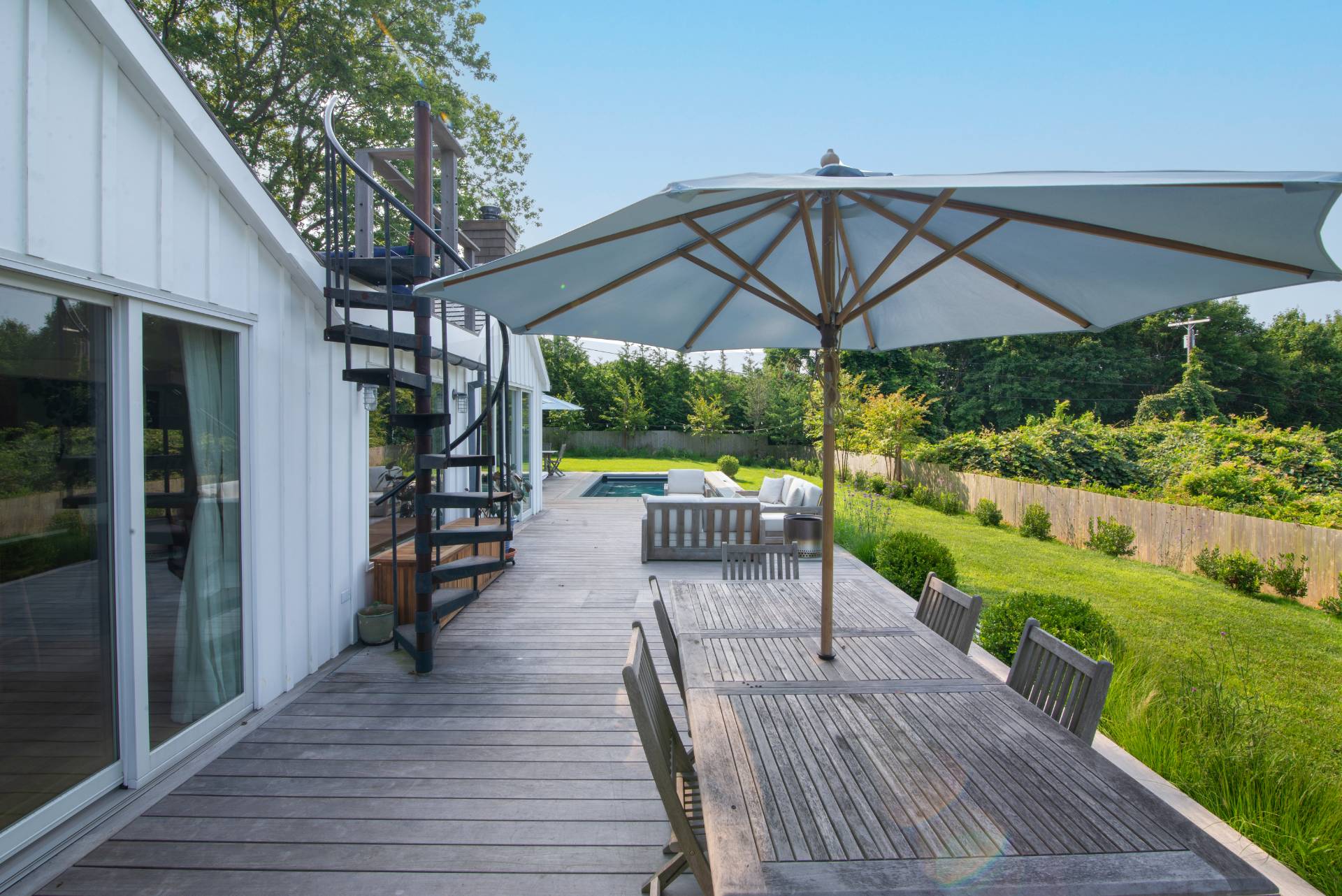 58 Fleming Road Montauk, NY 11954 - Photo 26 of 35 a view of a patio with a table chairs and a backyard
