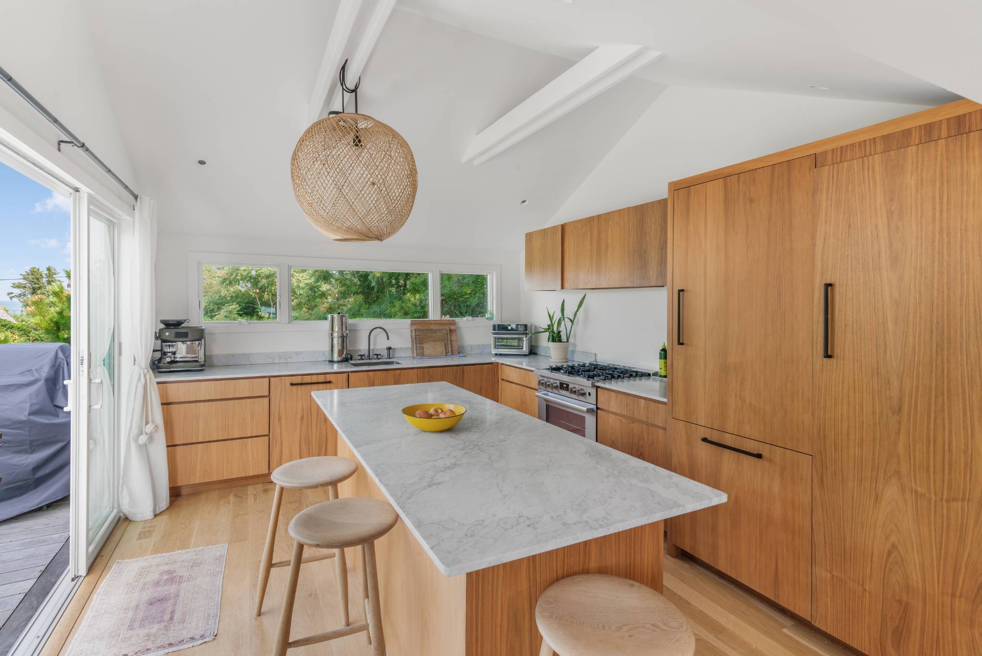 58 Fleming Road Montauk, NY 11954 - Photo 8 of 35 a kitchen with a table a stove and a refrigerator with wooden floor