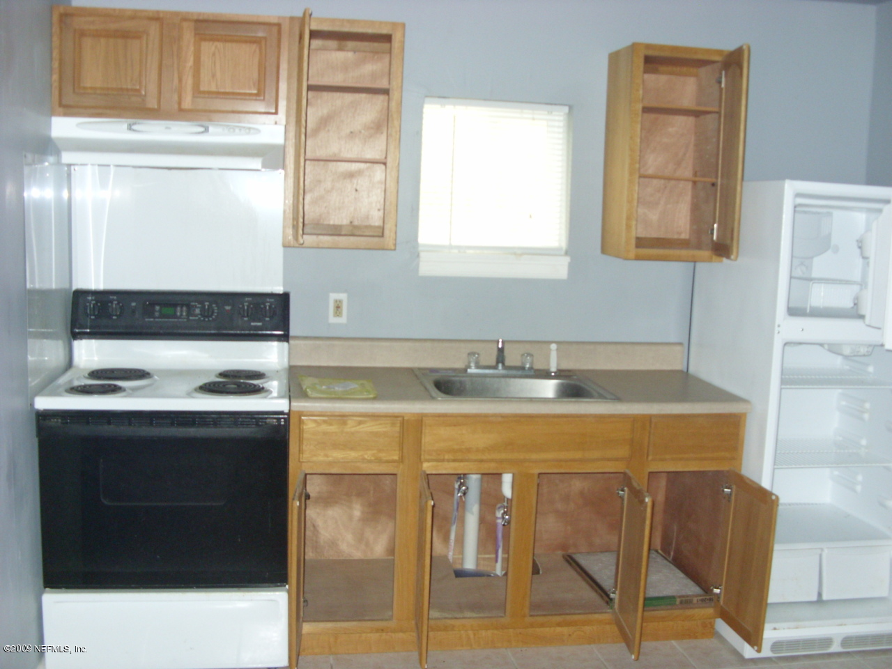 5657 Spellman Road Jacksonville, FL 32209 - Photo 2 of 5 a kitchen with a stove a sink and a refrigerator