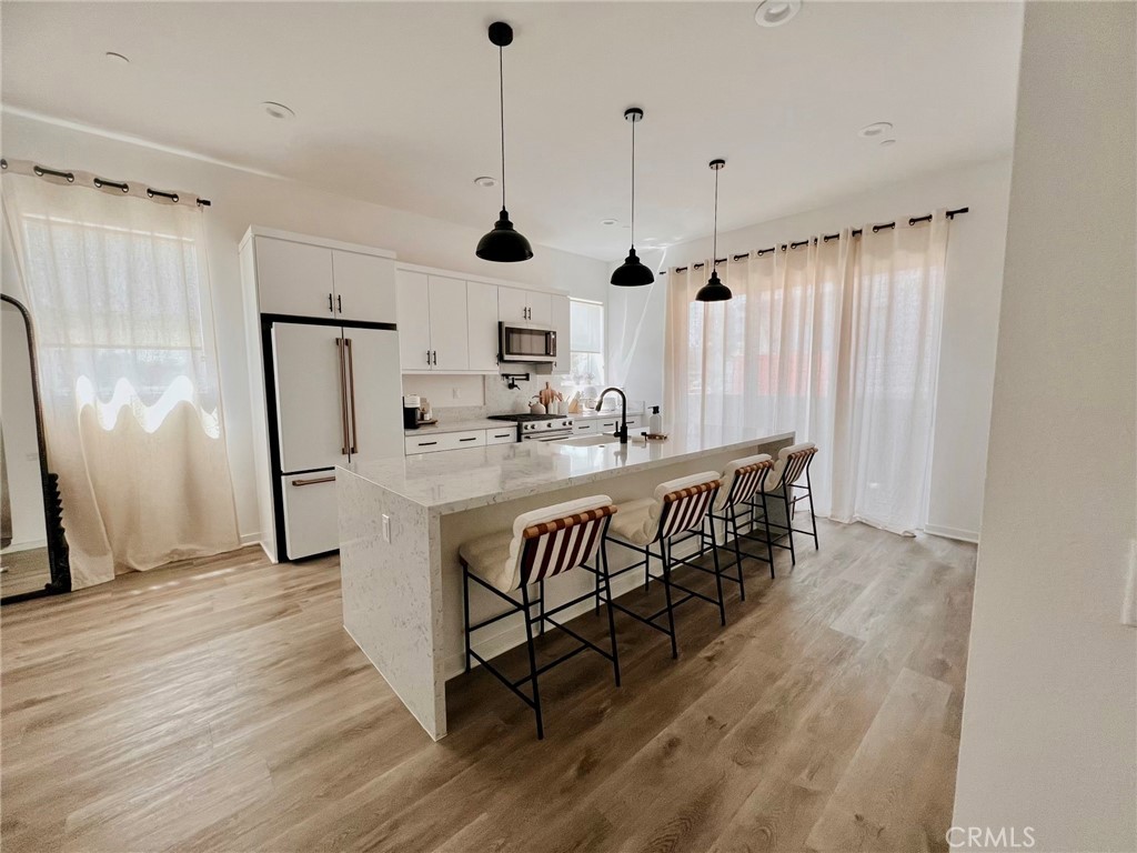 a kitchen with stainless steel appliances granite countertop a sink a stove and a refrigerator