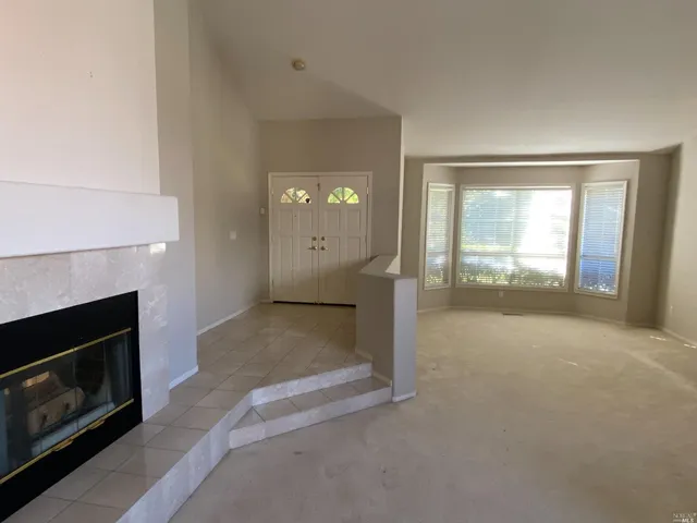 a view of a livingroom with wooden floor and a fireplace