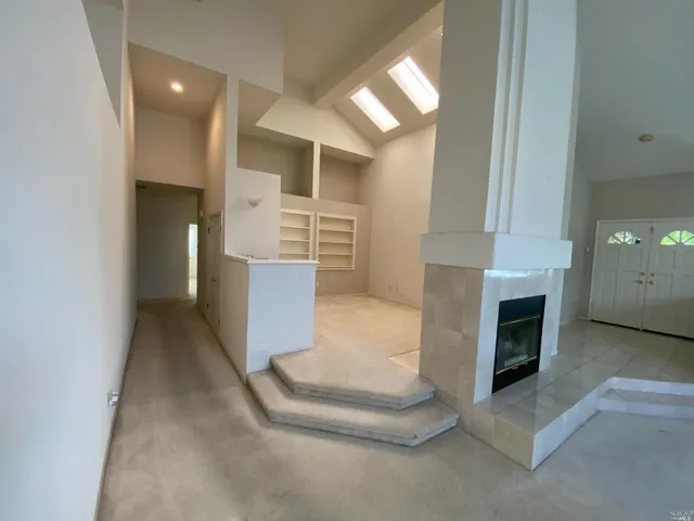 a view of entryway and hall with a fireplace