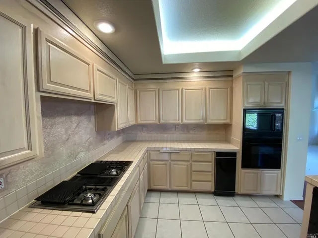 a kitchen with a stove sink and cabinets