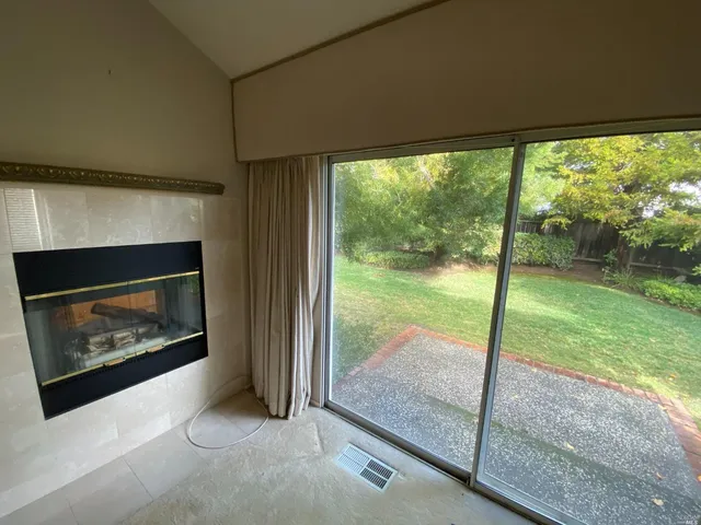 a living room with a fireplace and a floor to ceiling window