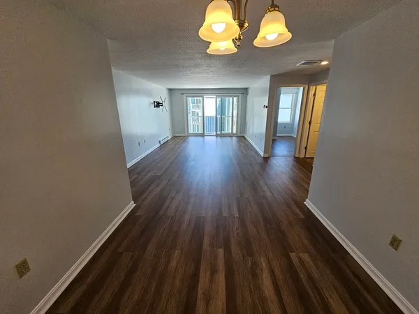 a view of a room with wooden floor