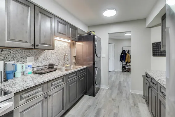 a kitchen with granite countertop cabinets stainless steel appliances a sink and wooden floor