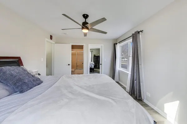 a spacious bedroom with a large bed and a chandelier