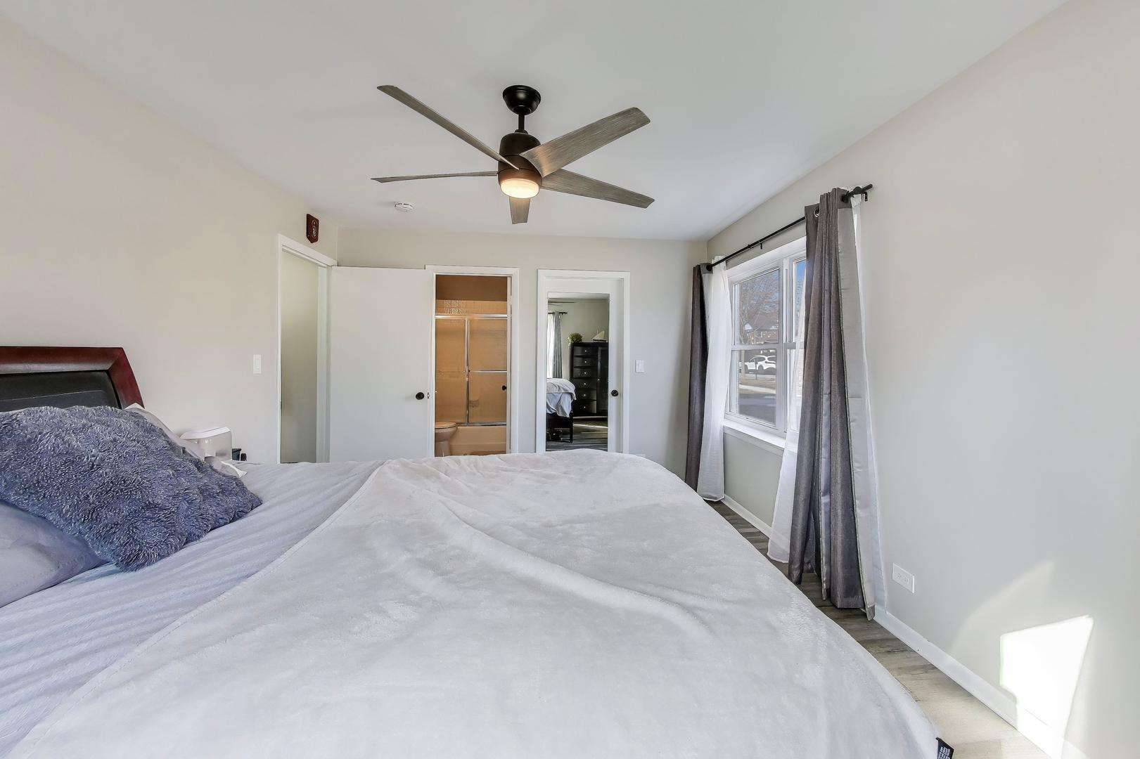 475 Shenstone Road, Unit 104 Riverside, IL 60546 - Photo 15 of 24 a spacious bedroom with a large bed and a chandelier