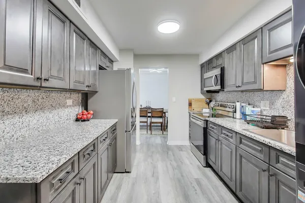 a kitchen with granite countertop lots of counter top space and stainless steel appliances