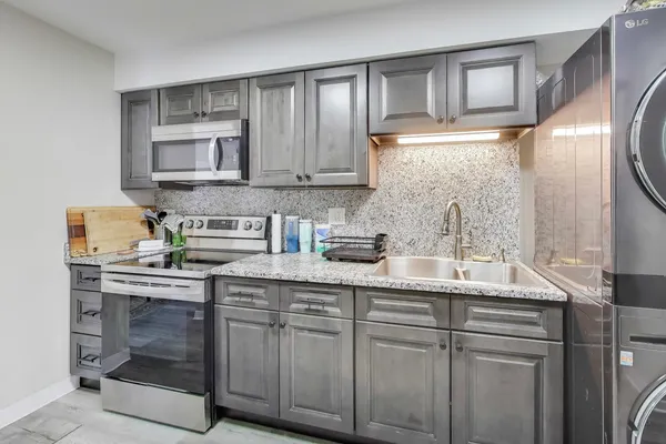 a kitchen with stainless steel appliances granite countertop a sink stove and cabinets