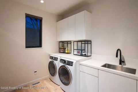 a utility room with sink dryer and washer