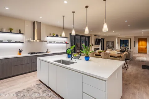 a kitchen with kitchen island granite countertop a sink and white cabinets