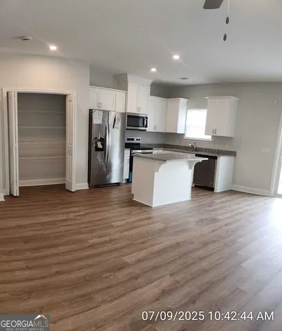 a kitchen with stainless steel appliances granite countertop a refrigerator and a stove