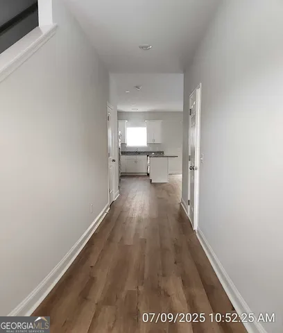 a view of a hallway with wooden floor