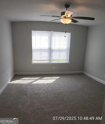 an empty room with a window and a fan