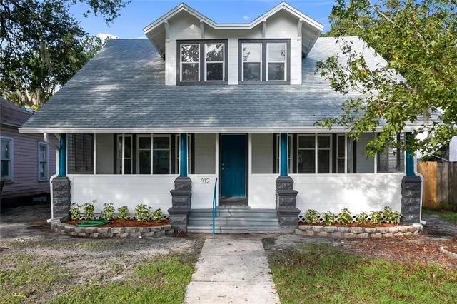 a front view of a house with sitting area and garden