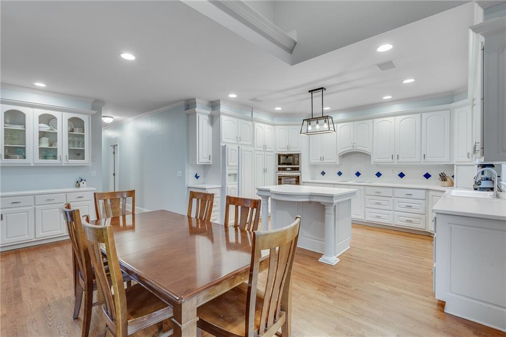 3969 Walkers Ridge Court Dacula, GA 30019 - Photo 21 of 60 a kitchen with granite countertop a table chairs stove microwave and cabinets