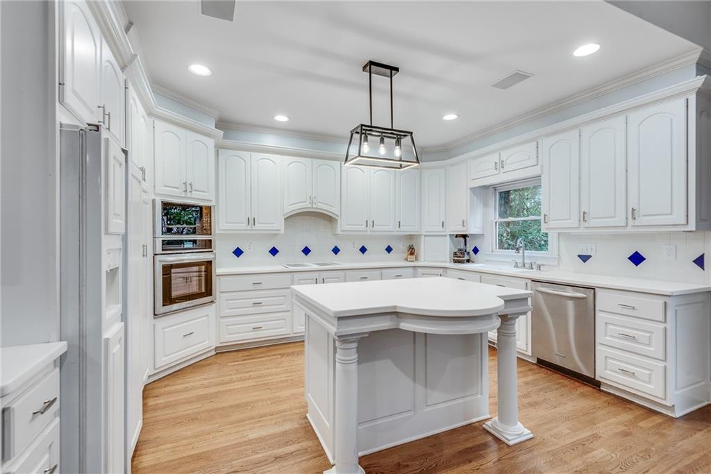 3969 Walkers Ridge Court Dacula, GA 30019 - Photo 23 of 60 a kitchen with stainless steel appliances kitchen island granite countertop a stove a sink and white cabinets with wooden floor