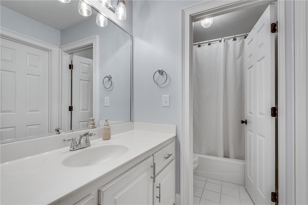 3969 Walkers Ridge Court Dacula, GA 30019 - Photo 47 of 60 a bathroom with a sink a mirror a vanity and a shower