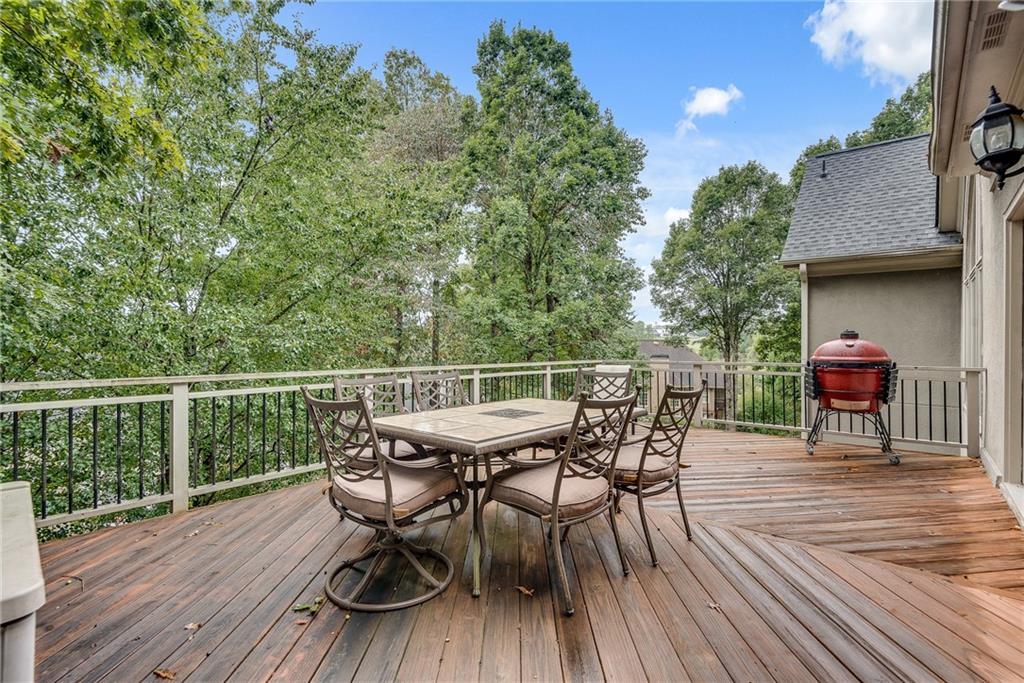 3969 Walkers Ridge Court Dacula, GA 30019 - Photo 57 of 60 a view of a roof deck with table and chairs with wooden floor and fence